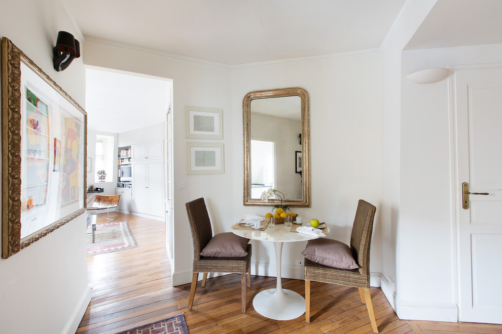 Offenes, Kleines Stilmix Esszimmer ohne Kamin mit weißer Wandfarbe und braunem Holzboden in Paris