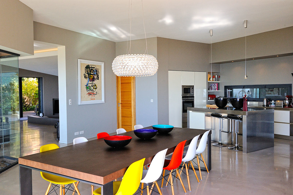 На фото: гостиная-столовая в современном стиле с серыми стенами и бетонным полом