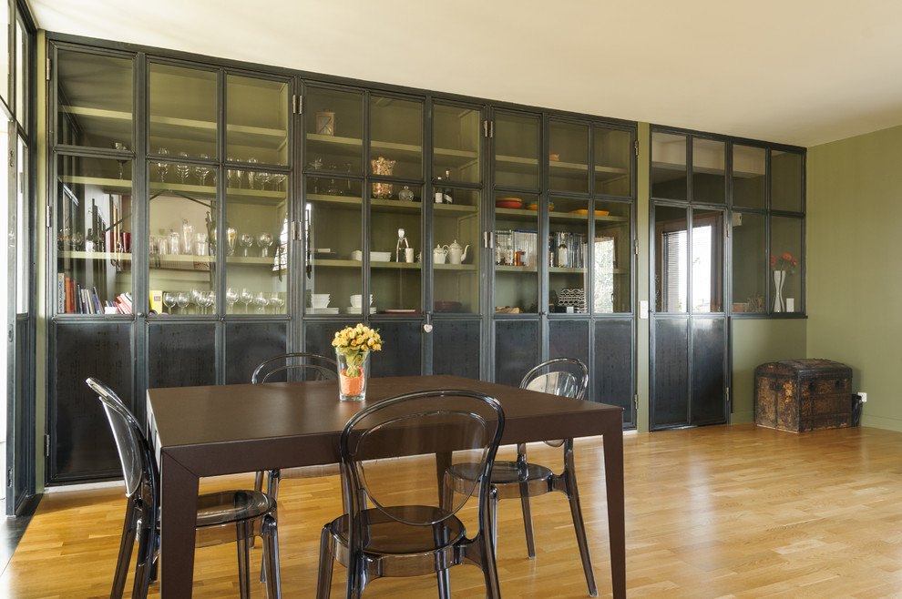 Immagine di una sala da pranzo aperta verso il soggiorno design di medie dimensioni con pareti verdi e pavimento in legno massello medio