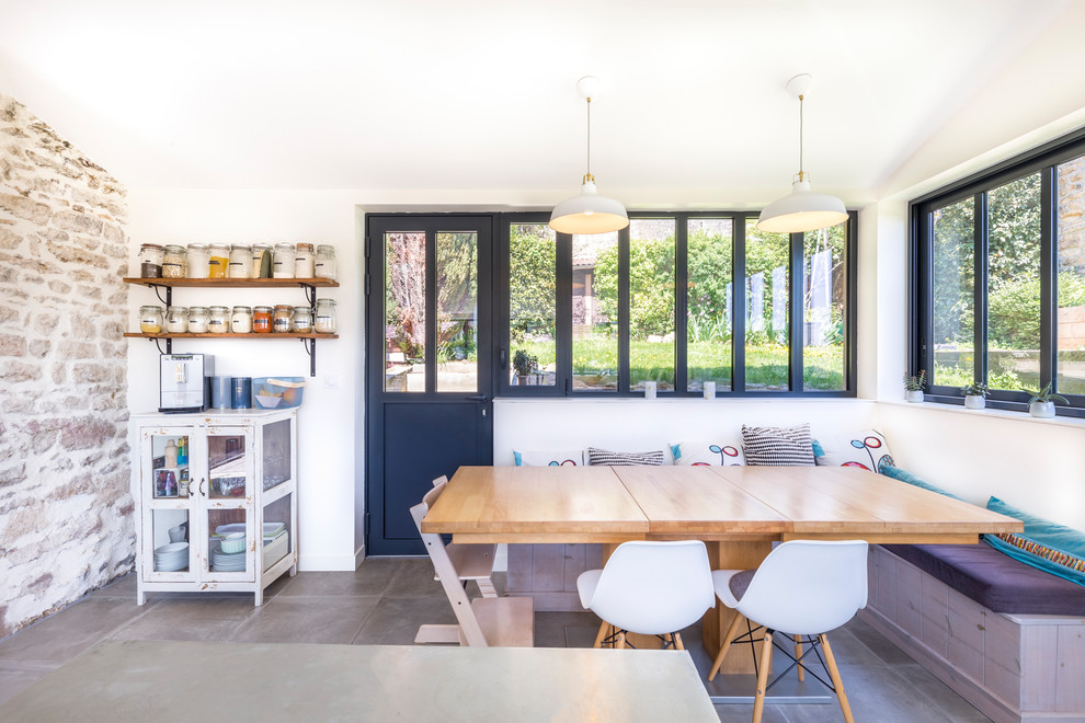 Esempio di una sala da pranzo aperta verso la cucina design con pareti bianche e pavimento grigio