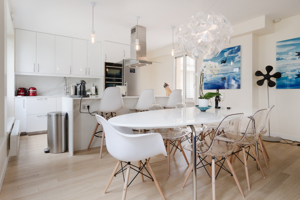 Inspiration pour une salle à manger ouverte sur la cuisine design de taille moyenne avec un mur blanc, parquet clair et un sol beige.