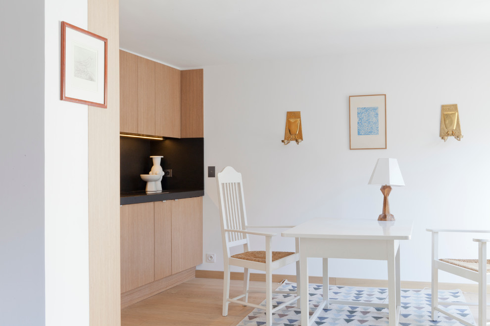 Inspiration pour une salle à manger ouverte sur la cuisine design de taille moyenne avec un mur blanc et parquet clair.