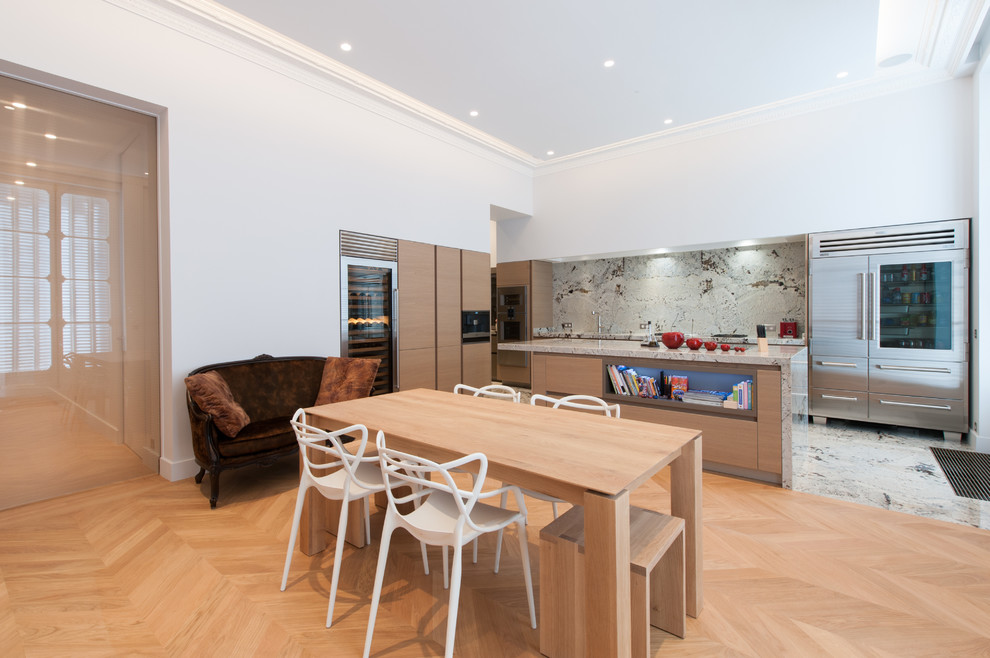 Immagine di una grande sala da pranzo aperta verso la cucina design con pareti bianche e parquet chiaro