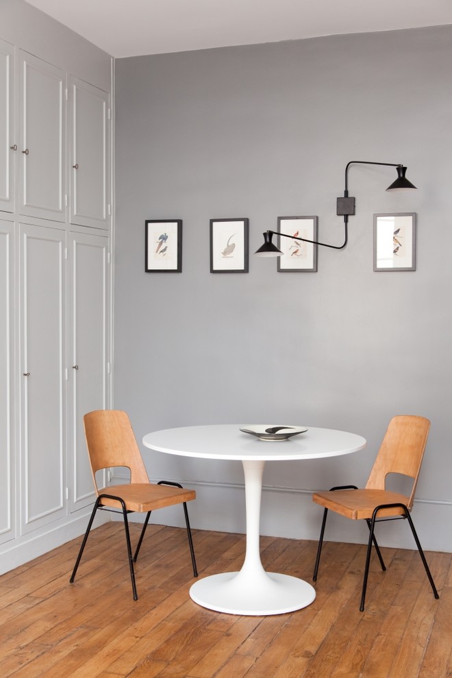 Idée de décoration pour une salle à manger design de taille moyenne et fermée avec un mur gris, un sol en bois brun et aucune cheminée.