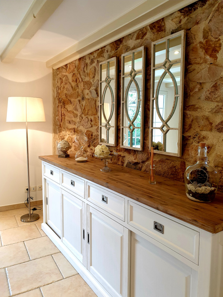 Пример оригинального дизайна: большая отдельная столовая в стиле неоклассика (современная классика) с белыми стенами, полом из терракотовой плитки, стандартным камином, бежевым полом и балками на потолке