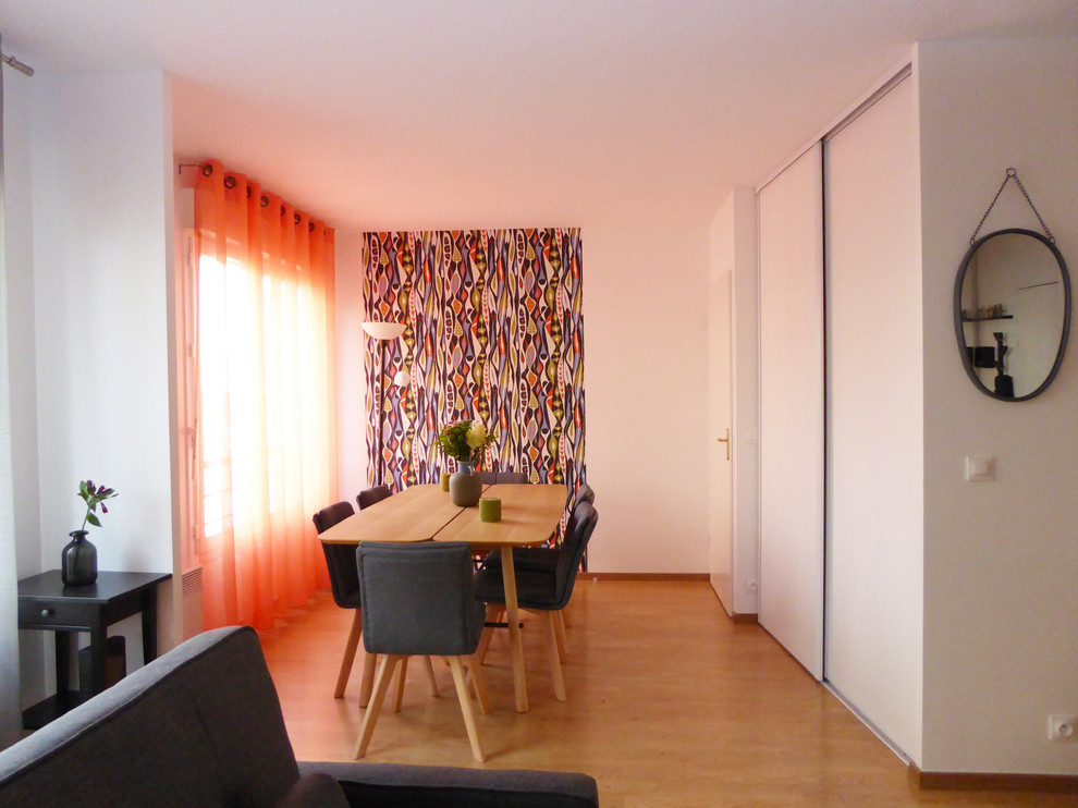 Exemple d'une salle à manger ouverte sur le salon tendance de taille moyenne avec un mur multicolore, parquet clair, aucune cheminée et un sol marron.