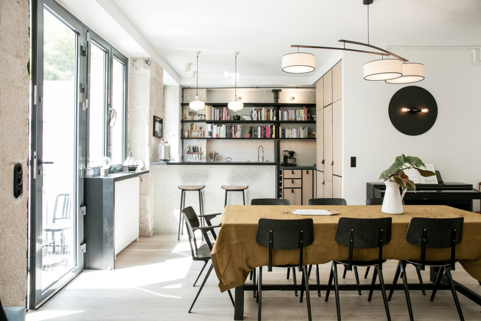 Photo of a scandi dining room in Paris with banquette seating and light hardwood flooring.