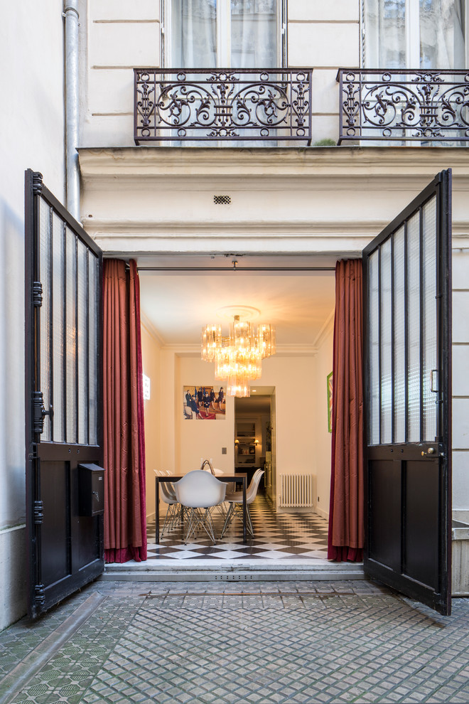 Contemporary enclosed dining room in Paris with white walls.
