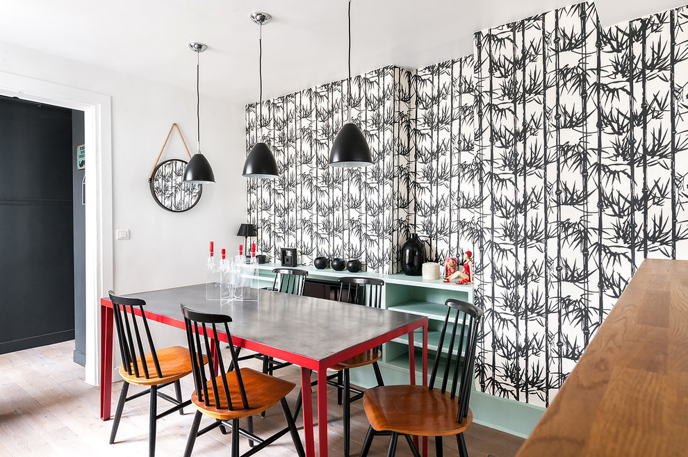 Immagine di una sala da pranzo minimal chiusa e di medie dimensioni con pareti multicolore, parquet chiaro e nessun camino