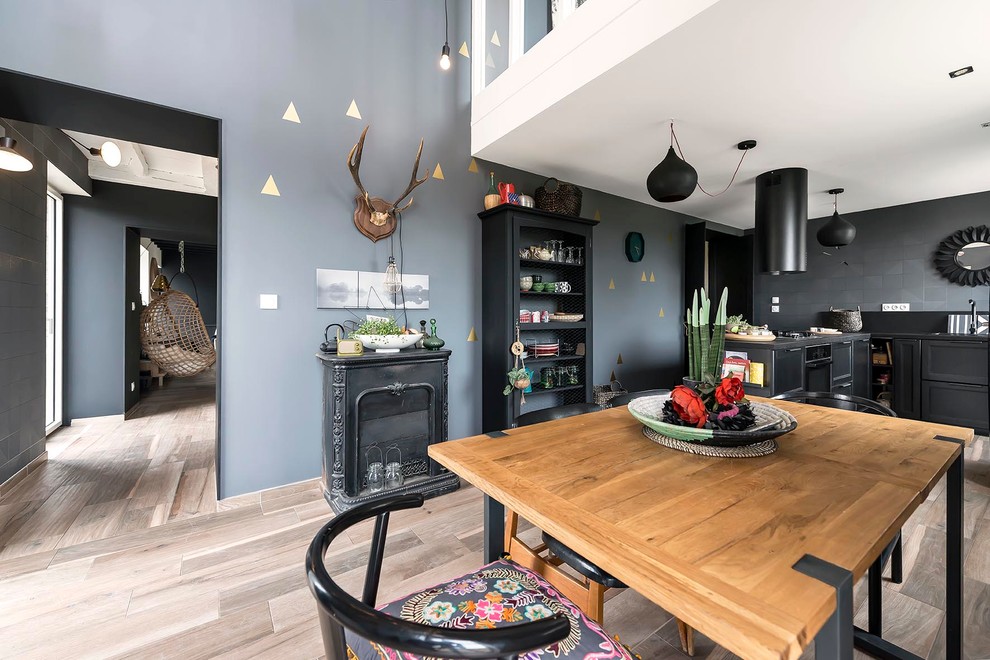 Mittelgroße Stilmix Wohnküche mit grauer Wandfarbe, hellem Holzboden und Kamin in Sonstige