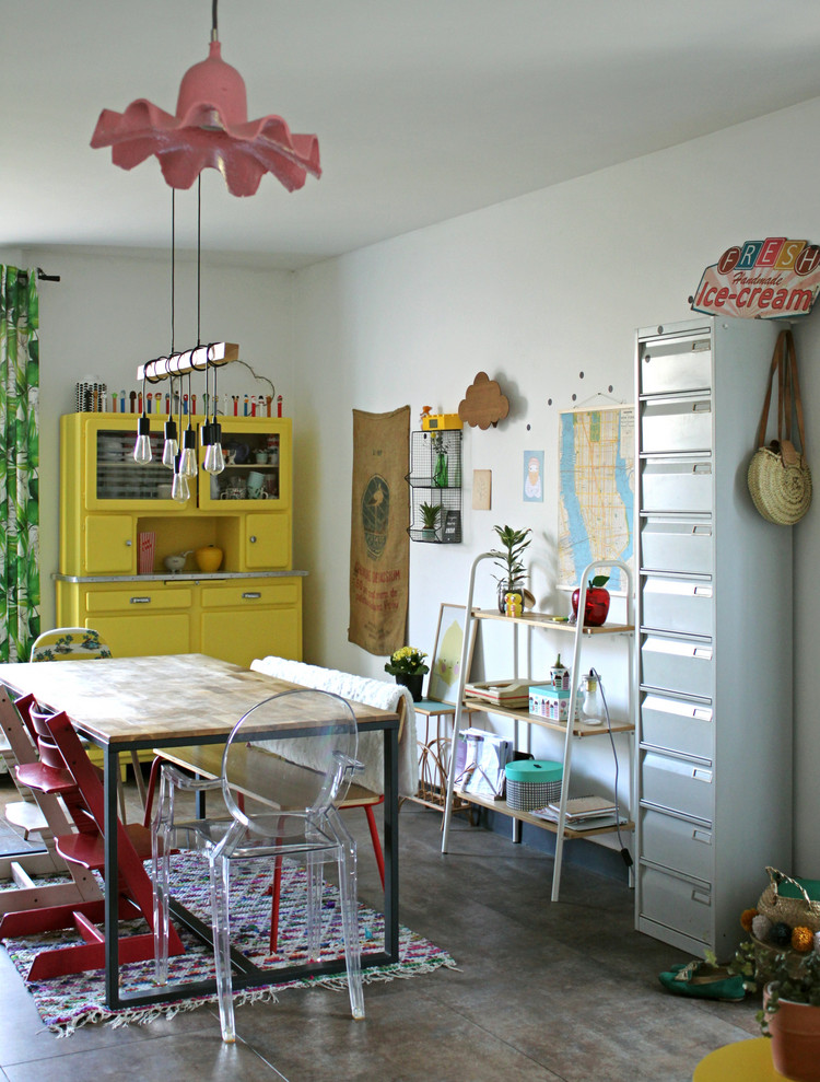 Cette photo montre une salle à manger éclectique avec un mur blanc et un sol gris.