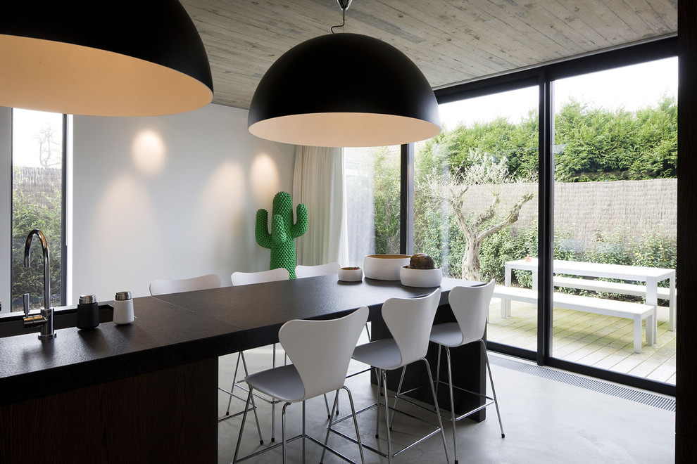 This is an example of a contemporary dining room in Lille with white walls.