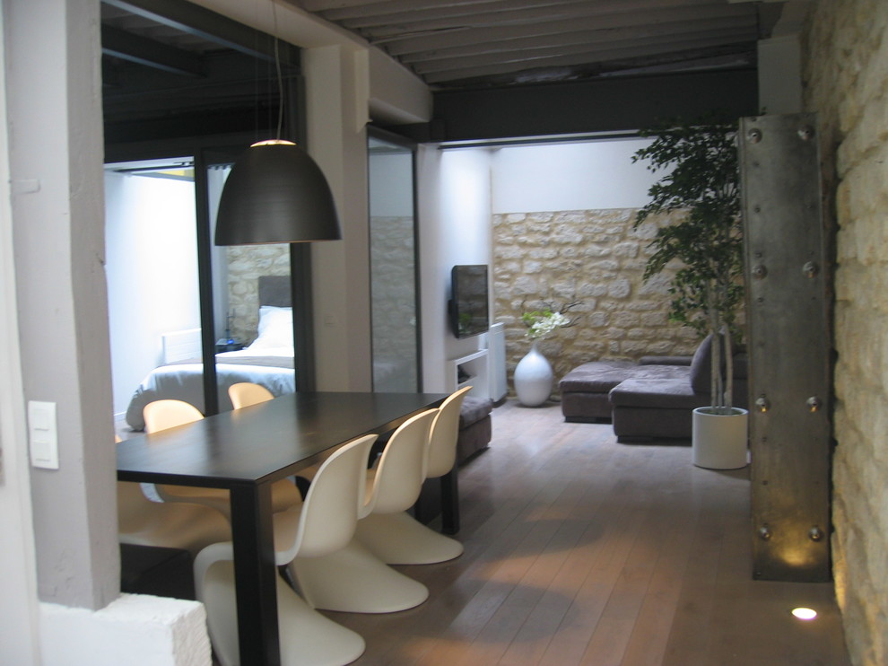 Cette image montre une salle à manger ouverte sur le salon design de taille moyenne avec un mur blanc.