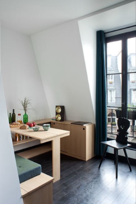 Cette photo montre une petite salle à manger ouverte sur le salon éclectique avec un mur blanc, un sol noir et parquet foncé.