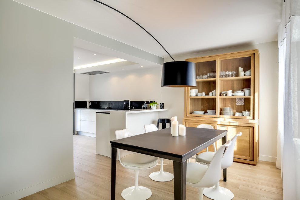 Стильный дизайн: гостиная-столовая среднего размера в современном стиле с белыми стенами и светлым паркетным полом без камина - последний тренд