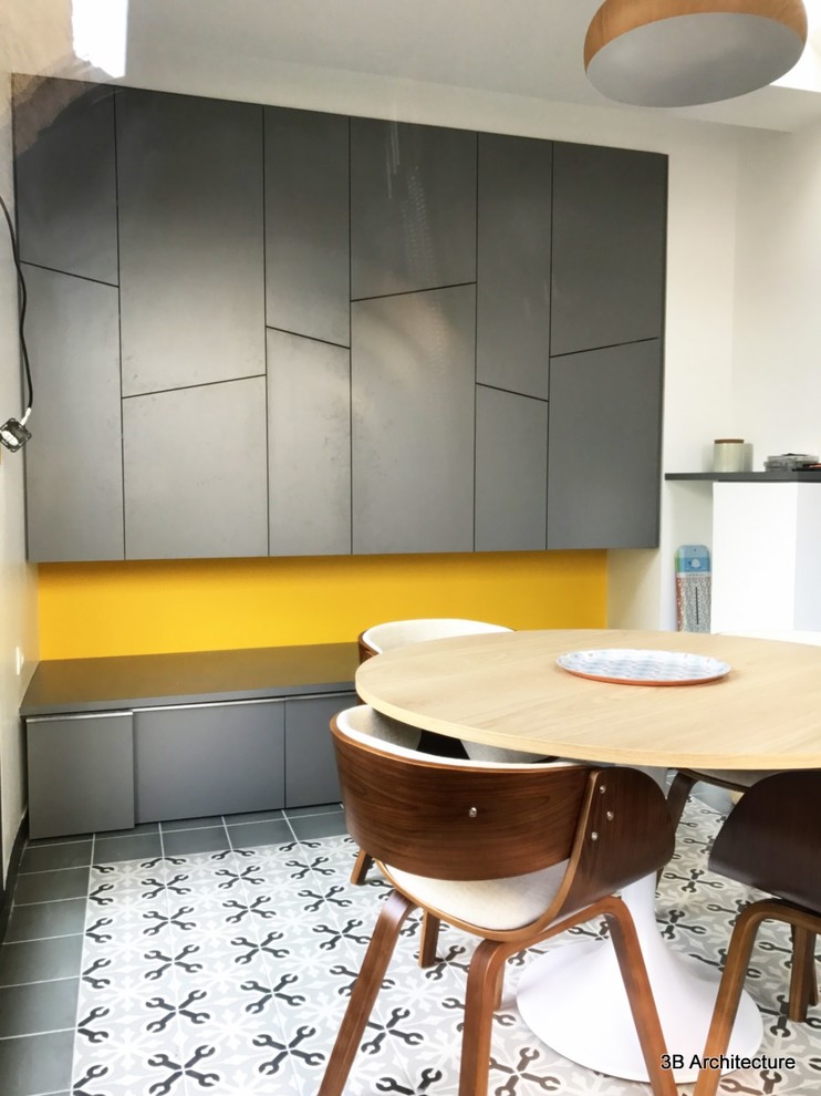 Foto di una piccola sala da pranzo contemporanea chiusa con pareti gialle, pavimento con piastrelle in ceramica e pavimento grigio