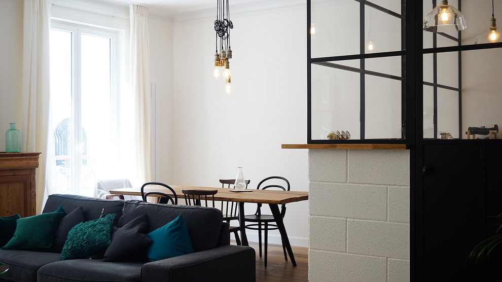 Idée de décoration pour une salle à manger ouverte sur le salon urbaine de taille moyenne avec un mur blanc, un sol en bois brun et aucune cheminée.