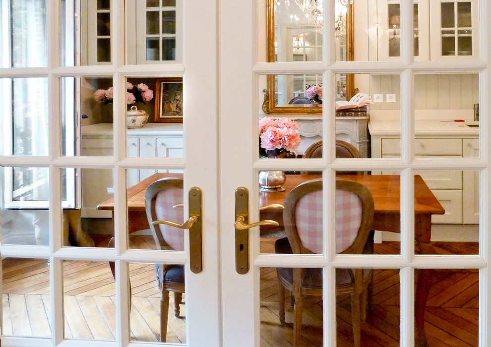 Esempio di una sala da pranzo aperta verso la cucina rustica di medie dimensioni con pareti beige, pavimento in legno massello medio e camino classico