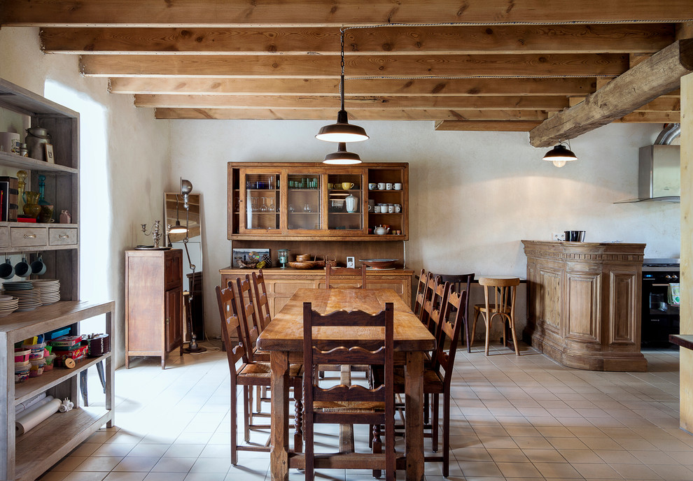 Cette image montre une salle à manger ouverte sur le salon rustique avec un mur blanc et un sol beige.