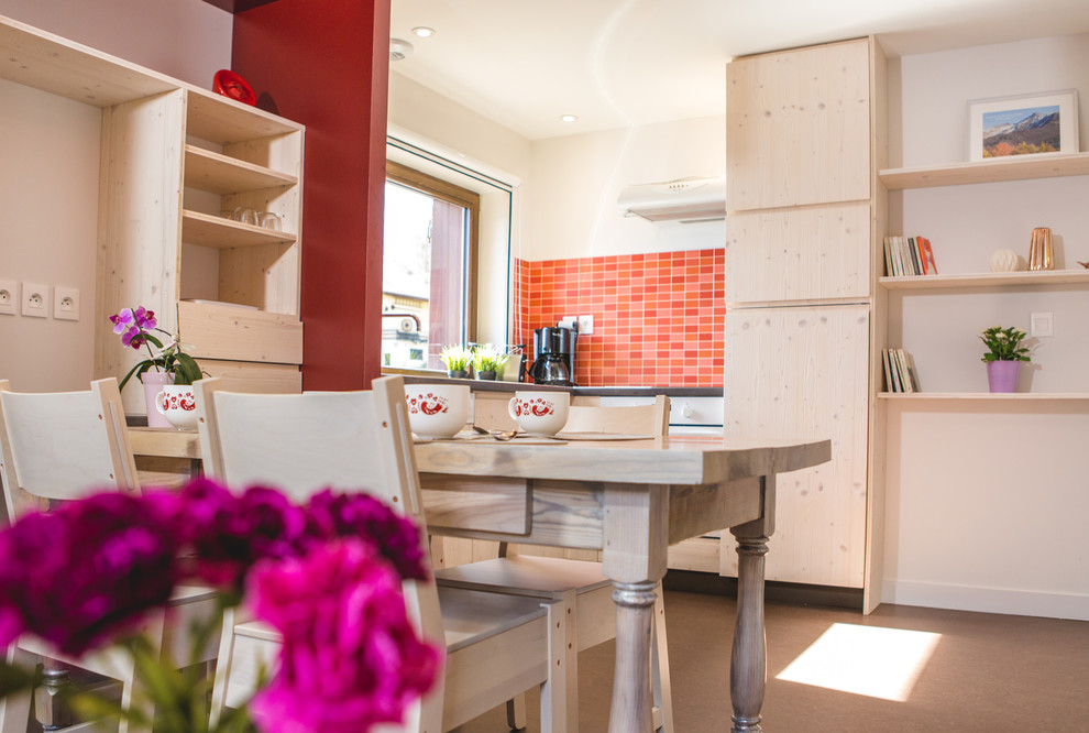 Immagine di una piccola sala da pranzo aperta verso il soggiorno nordica con pareti rosse, pavimento in linoleum e pavimento marrone