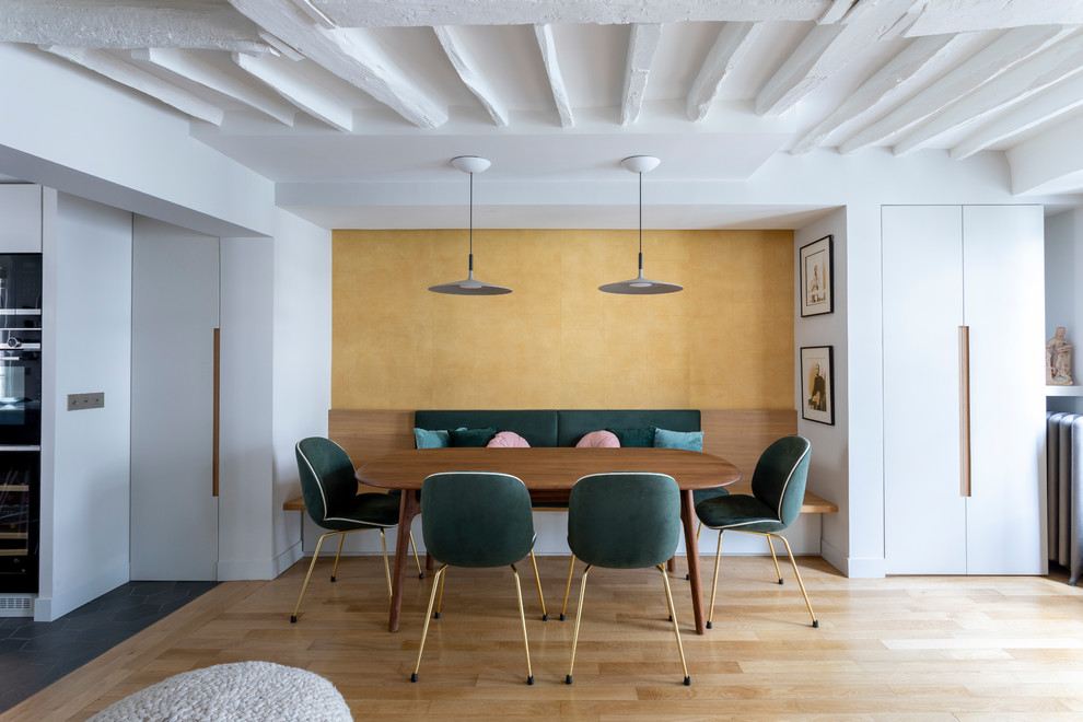Idée de décoration pour une petite salle à manger ouverte sur le salon design avec un mur jaune, parquet clair, aucune cheminée et un sol beige.