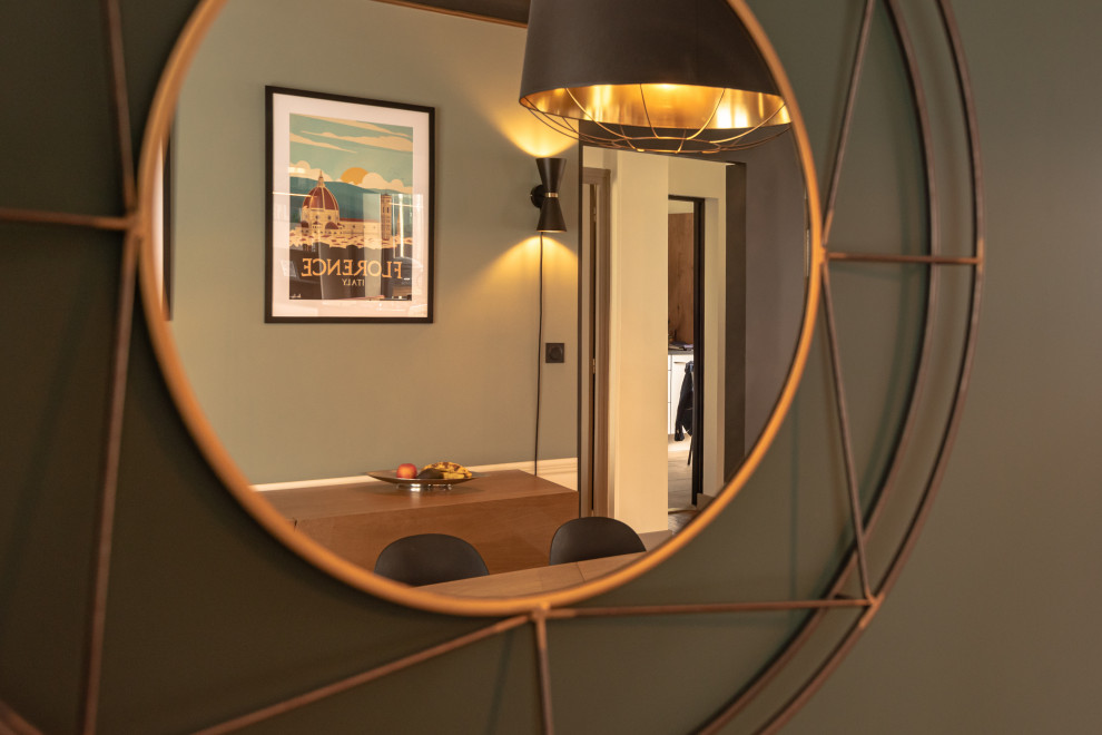Cette image montre une salle à manger minimaliste avec un mur vert, parquet foncé et du papier peint.