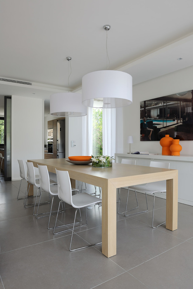 Idee per una sala da pranzo aperta verso il soggiorno design con pareti bianche e pavimento grigio