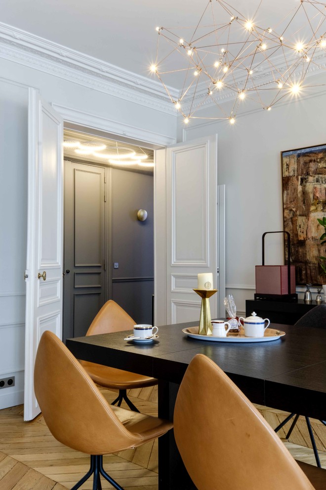 Photo of a contemporary dining room in Paris with feature lighting.