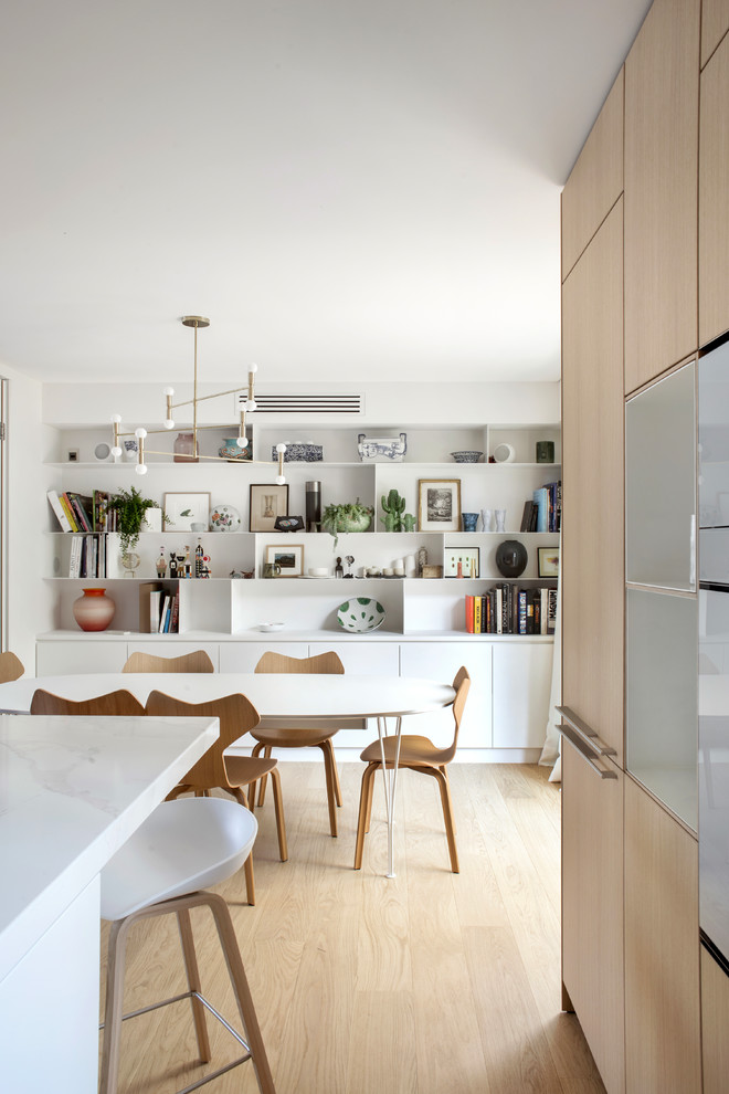 Idee per una sala da pranzo aperta verso il soggiorno minimal con pareti bianche, parquet chiaro e pavimento beige