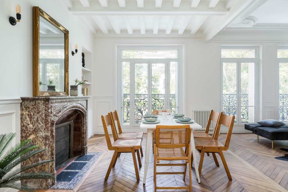 Inspiration pour une salle à manger ouverte sur le salon design avec un mur blanc, un sol en bois brun, une cheminée ribbon et un manteau de cheminée en pierre.