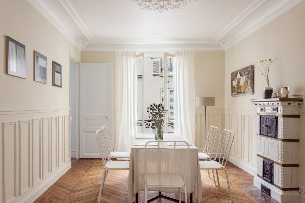 Immagine di una sala da pranzo classica con pareti beige, pavimento in legno massello medio, pavimento marrone e boiserie