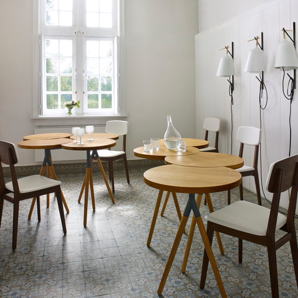 Immagine di una sala da pranzo nordica chiusa e di medie dimensioni con pareti bianche, pavimento con piastrelle in ceramica e nessun camino