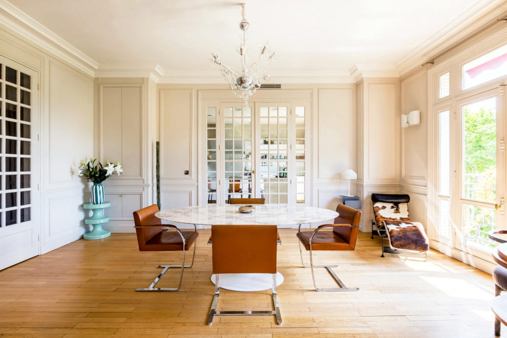 Offenes, Großes Klassisches Esszimmer ohne Kamin mit beiger Wandfarbe, hellem Holzboden und beigem Boden in Paris