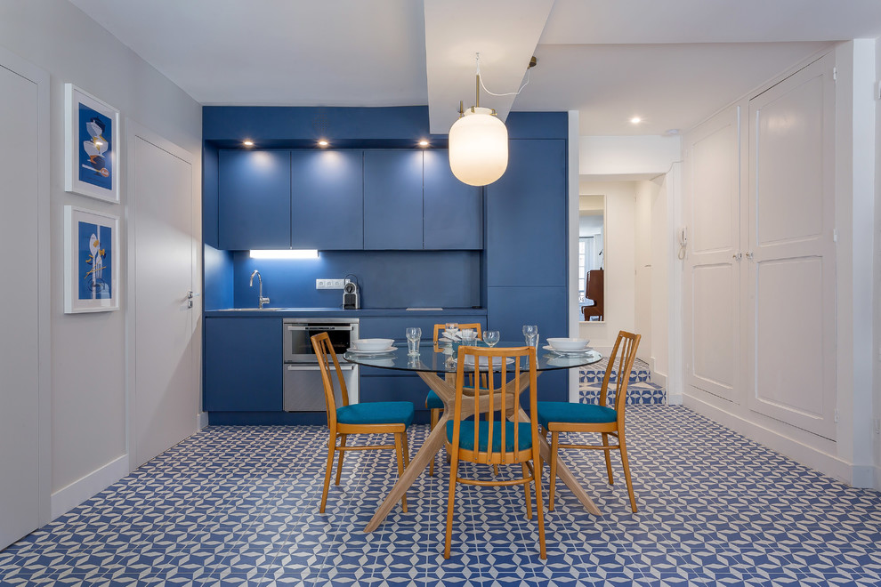 Ejemplo de comedor de cocina contemporáneo con paredes azules y suelo azul