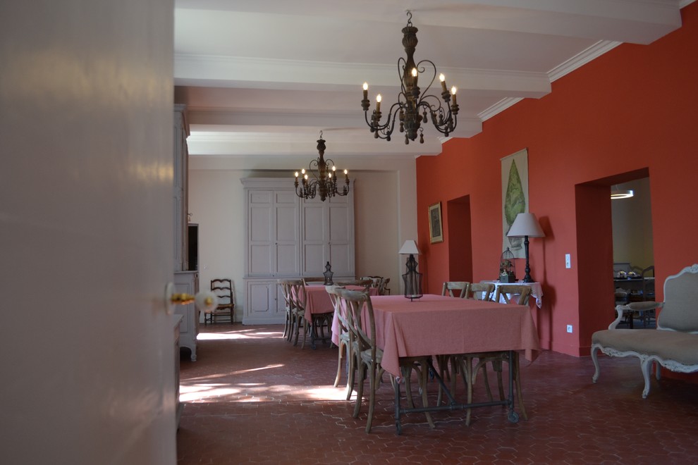 Ejemplo de comedor clásico de tamaño medio abierto con paredes rojas y suelo de baldosas de terracota