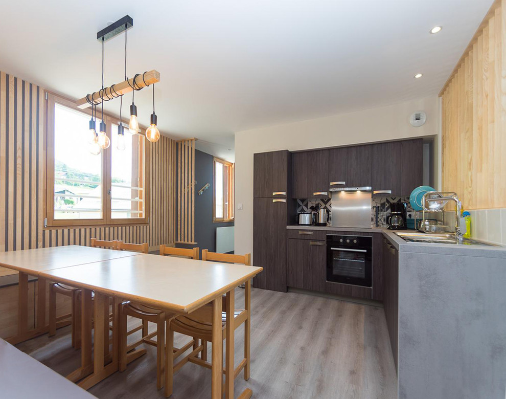 Cette image montre une cuisine ouverte nordique avec parquet clair et un sol gris.