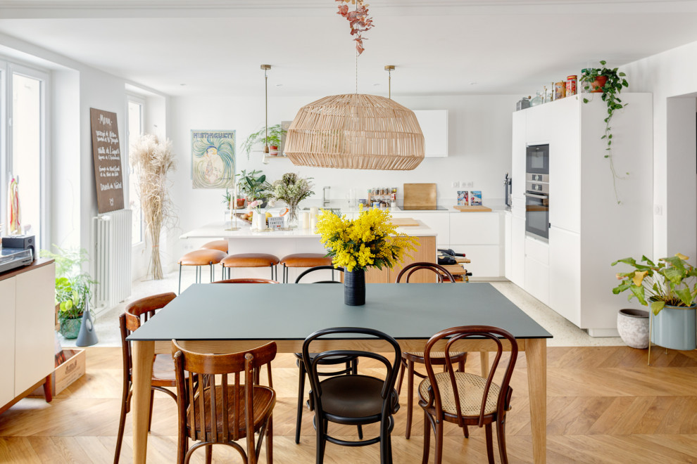 Exemple d'une salle à manger ouverte sur la cuisine scandinave de taille moyenne avec un mur blanc, un sol en bois brun et un sol marron.