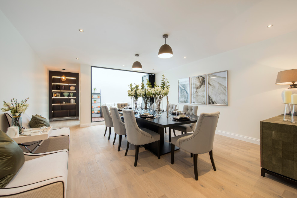 Large contemporary dining room in London with beige walls, light hardwood flooring and beige floors.