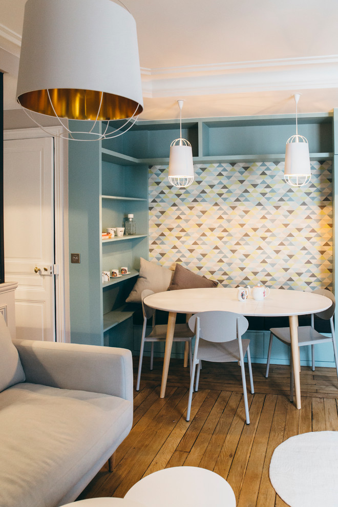 Aménagement d'une salle à manger ouverte sur le salon contemporaine de taille moyenne avec un mur bleu, un sol en bois brun et aucune cheminée.