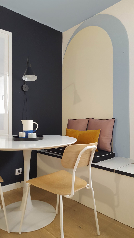 Esempio di una sala da pranzo aperta verso il soggiorno eclettica di medie dimensioni con pareti nere, parquet chiaro, pavimento beige e pareti in legno