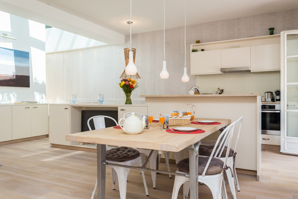 Idée de décoration pour une salle à manger ouverte sur la cuisine design de taille moyenne avec un mur beige et parquet clair.