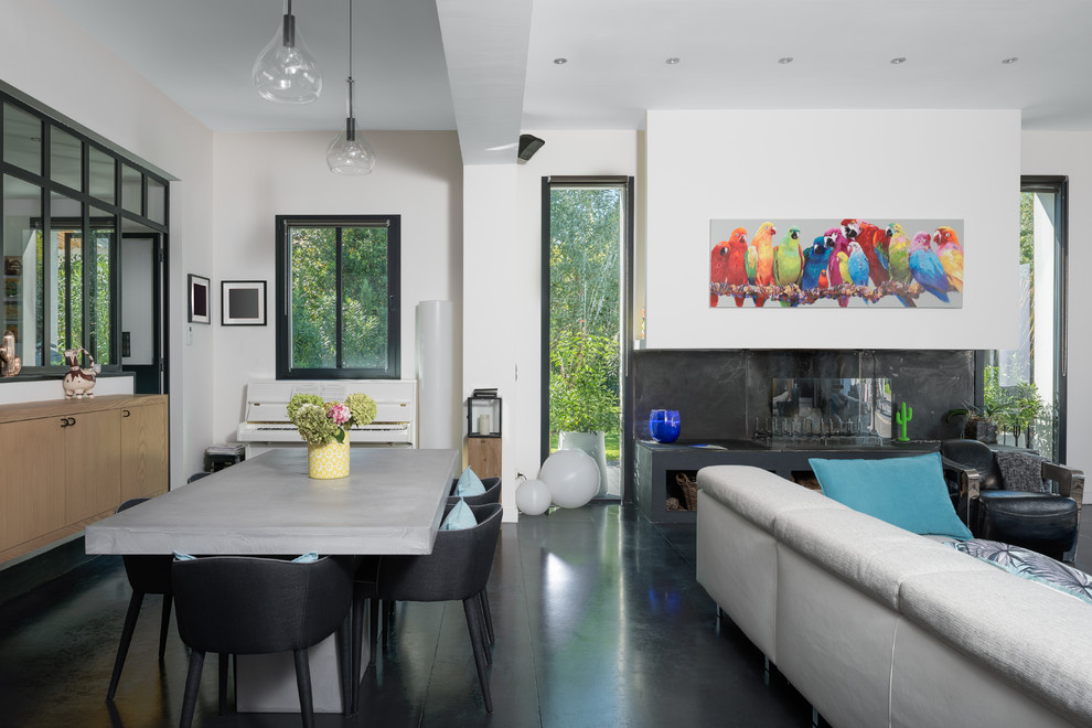 Идея дизайна: гостиная-столовая в современном стиле с белыми стенами, горизонтальным камином и черным полом