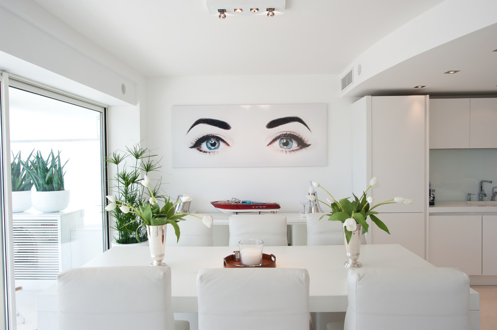 Immagine di una sala da pranzo aperta verso la cucina contemporanea con pareti bianche