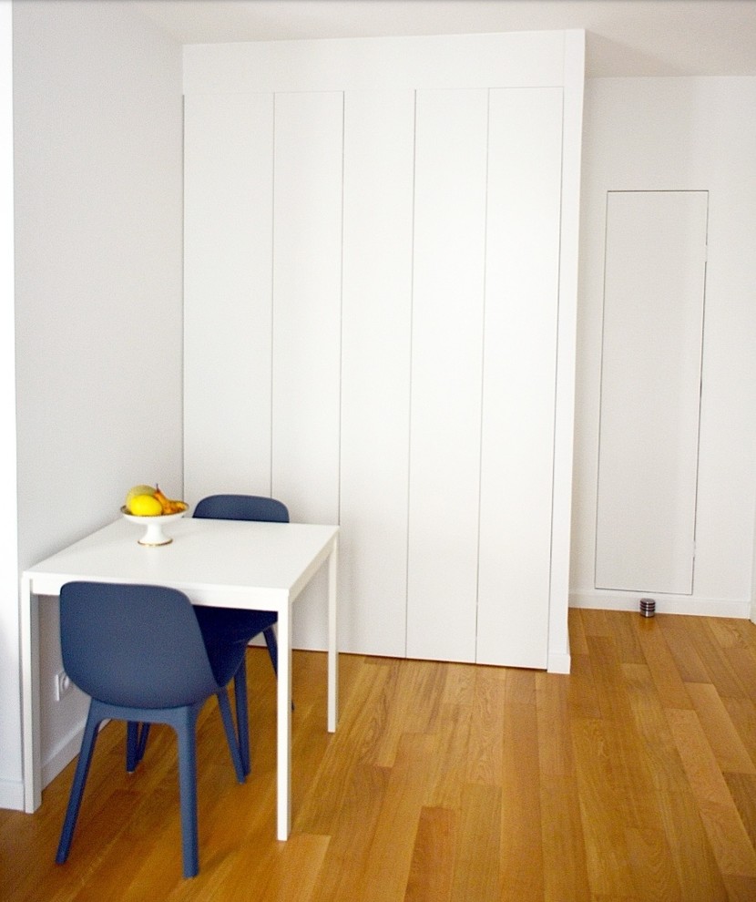 Idée de décoration pour une salle à manger ouverte sur le salon design de taille moyenne avec un mur blanc et parquet clair.