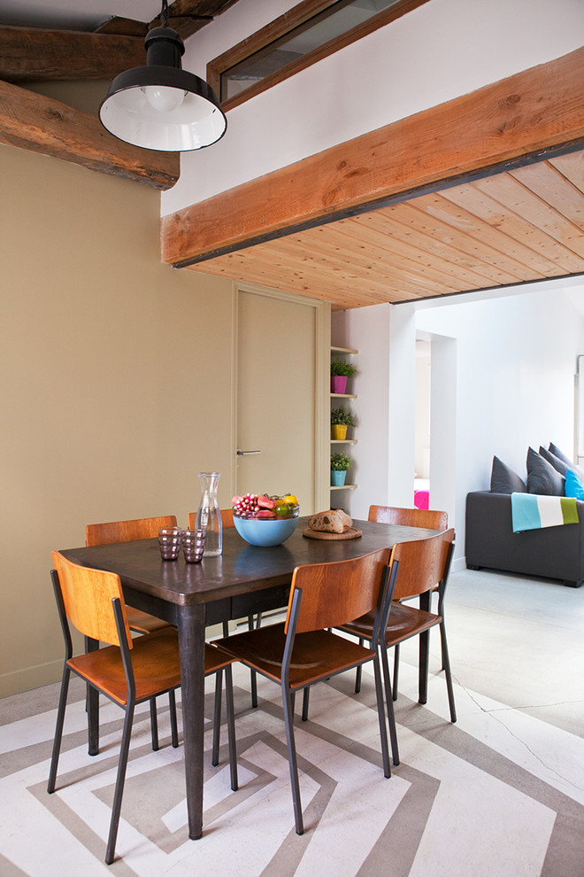 Foto di una sala da pranzo aperta verso il soggiorno minimal di medie dimensioni con pareti beige e pavimento in cemento