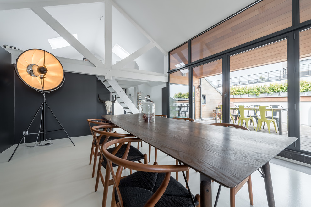 Ispirazione per una sala da pranzo aperta verso il soggiorno contemporanea con pareti nere e pavimento grigio