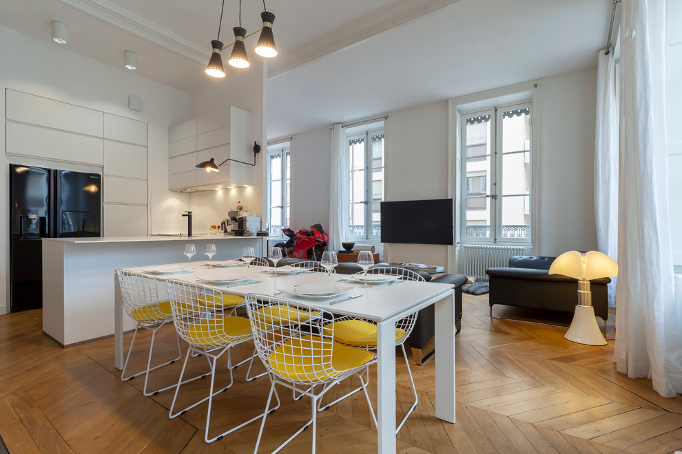 Immagine di una sala da pranzo aperta verso il soggiorno minimal di medie dimensioni con pareti bianche e parquet chiaro