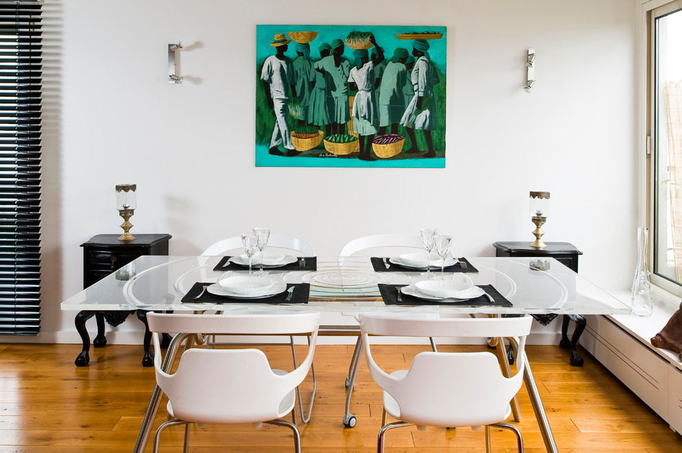 Dining room - contemporary medium tone wood floor dining room idea in Paris with white walls