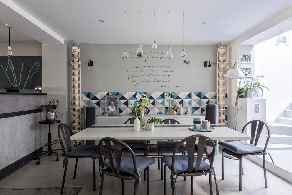 Idées déco pour une salle à manger ouverte sur la cuisine contemporaine de taille moyenne avec un mur multicolore, sol en béton ciré et aucune cheminée.