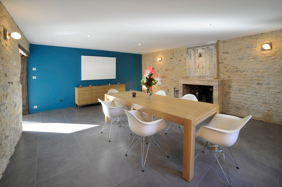 Inspiration pour une salle à manger ouverte sur le salon design de taille moyenne avec un mur bleu, une cheminée standard et un sol en carrelage de céramique.